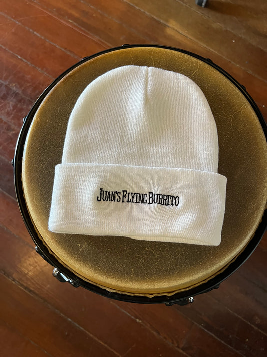 A white beanie with black embroidered "Juan's Flying Burrito" across the cuff